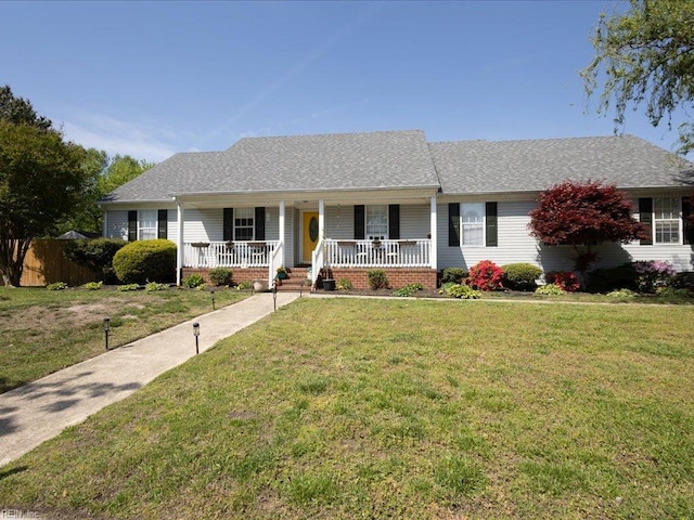 ranch-style house featuring a front lawn, fence, roof with shingles, and covered porch