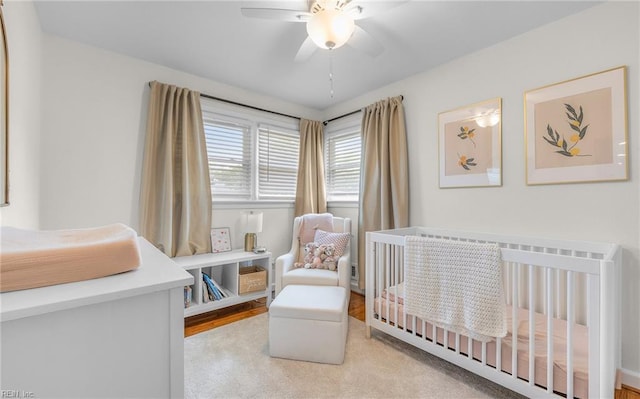 bedroom with a crib and a ceiling fan