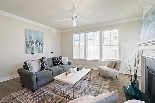living area featuring ceiling fan, baseboards, ornamental molding, and wood finished floors