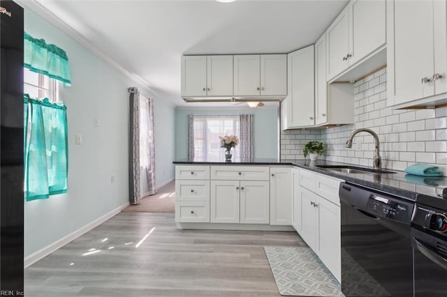 kitchen with a sink, tasteful backsplash, black appliances, white cabinetry, and ornamental molding