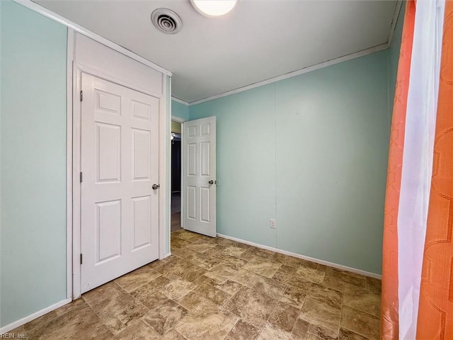 unfurnished bedroom with crown molding, visible vents, stone finish floor, and baseboards