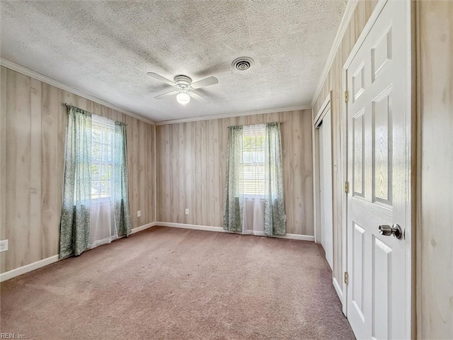 spare room featuring a textured ceiling, visible vents, ceiling fan, and carpet floors