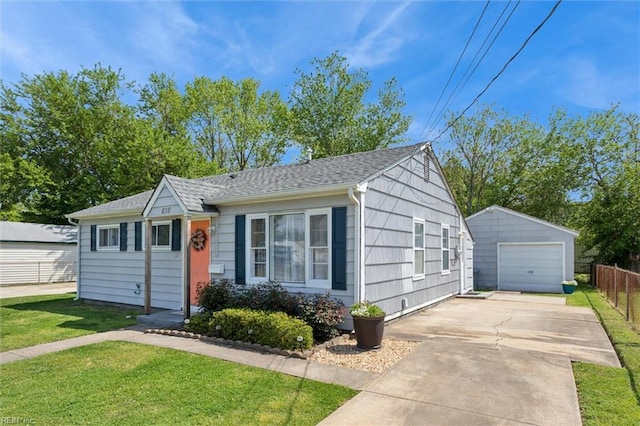 view of front facade with fence, an outbuilding, a garage, a front yard, and concrete driveway