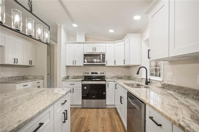 kitchen with recessed lighting, stainless steel appliances, a sink, and white cabinetry