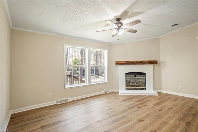 unfurnished living room with a textured ceiling, wood finished floors, visible vents, and a ceiling fan