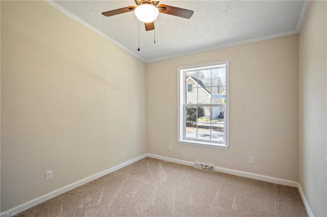 carpeted spare room featuring a textured ceiling, visible vents, crown molding, and a ceiling fan