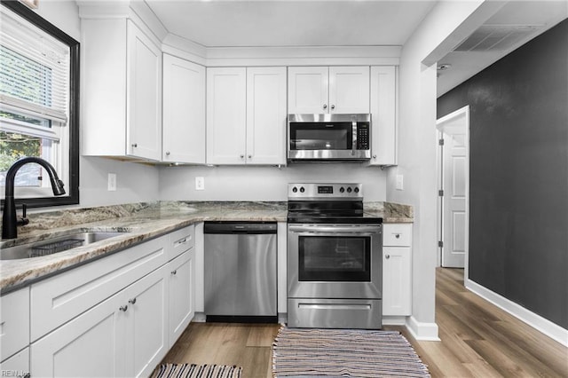 kitchen with light wood finished floors, visible vents, appliances with stainless steel finishes, and a sink