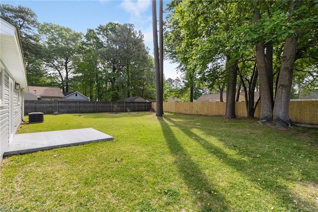 view of yard with a patio area, a fenced backyard, and central AC