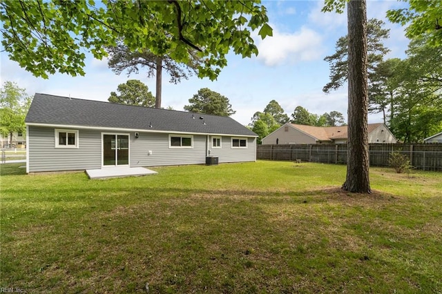 rear view of house with a yard, a patio area, central AC unit, and fence