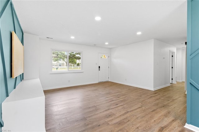 unfurnished living room with baseboards, light wood-style flooring, visible vents, and recessed lighting