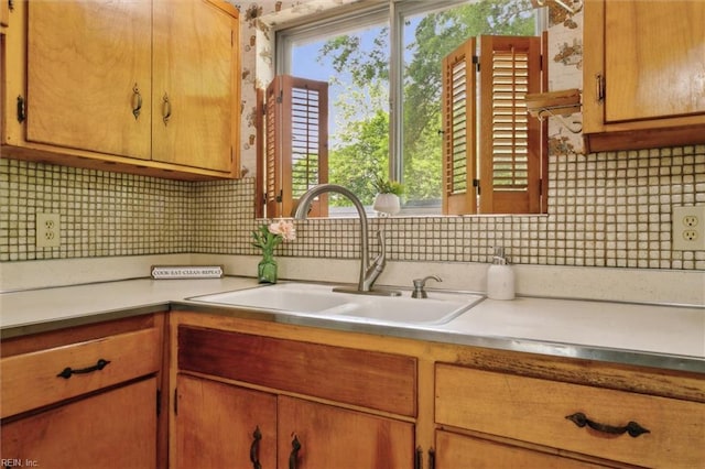 kitchen with light countertops, tasteful backsplash, and a sink
