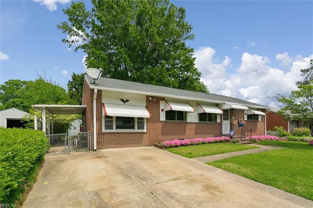 view of front of property with an attached carport, a gate, driveway, brick siding, and a front yard