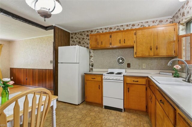 kitchen with wallpapered walls, light floors, light countertops, a sink, and white appliances
