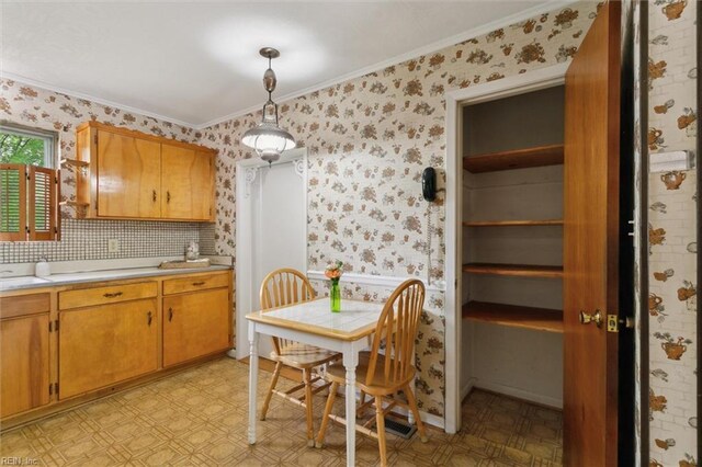 dining area featuring light floors, ornamental molding, and wallpapered walls