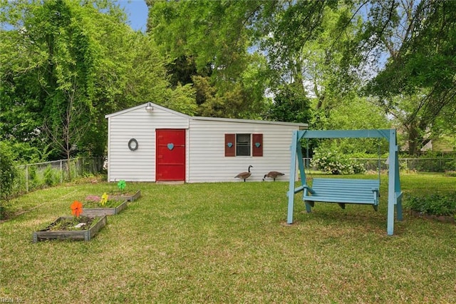 view of outbuilding featuring a fenced backyard, an outdoor structure, and a vegetable garden