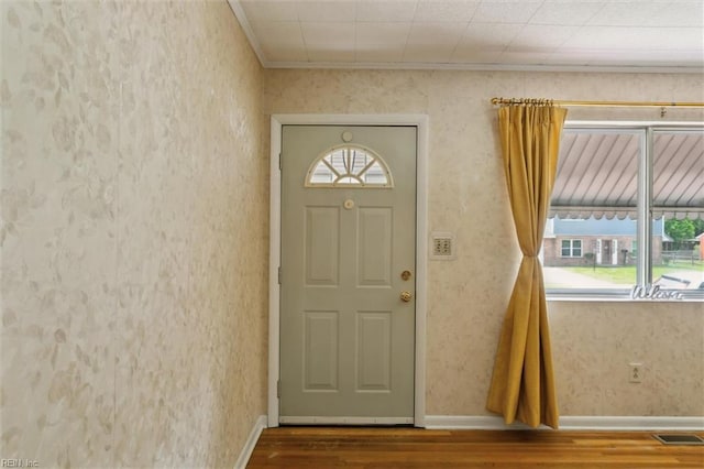 foyer with plenty of natural light, wood finished floors, visible vents, and baseboards
