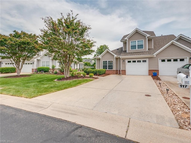 view of front of home featuring a shingled roof, brick siding, a front yard, and concrete driveway