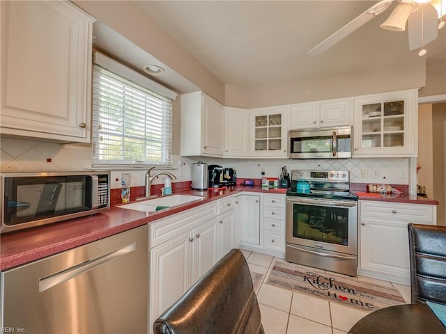 kitchen with backsplash, light tile patterned flooring, stainless steel appliances, and a sink