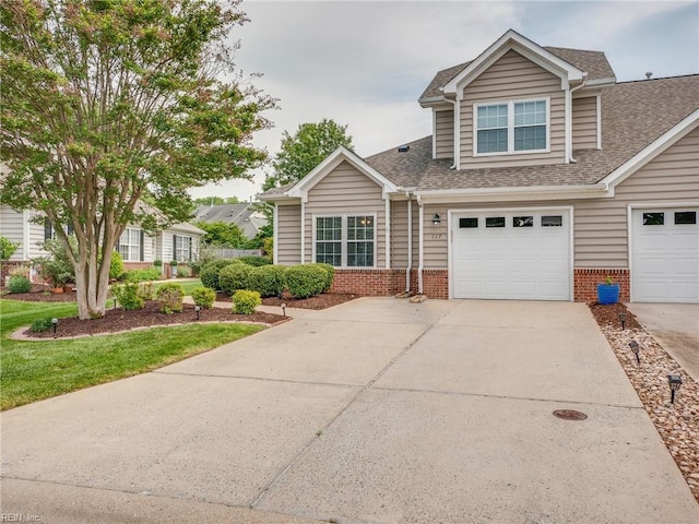 view of front of home with brick siding, driveway, a garage, and roof with shingles