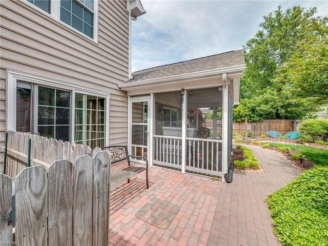 view of patio / terrace featuring a sunroom and fence
