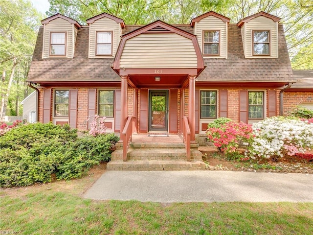 view of front of home featuring brick siding and a shingled roof