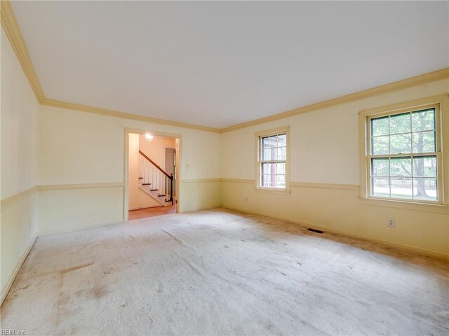 empty room featuring baseboards, ornamental molding, carpet flooring, and stairs