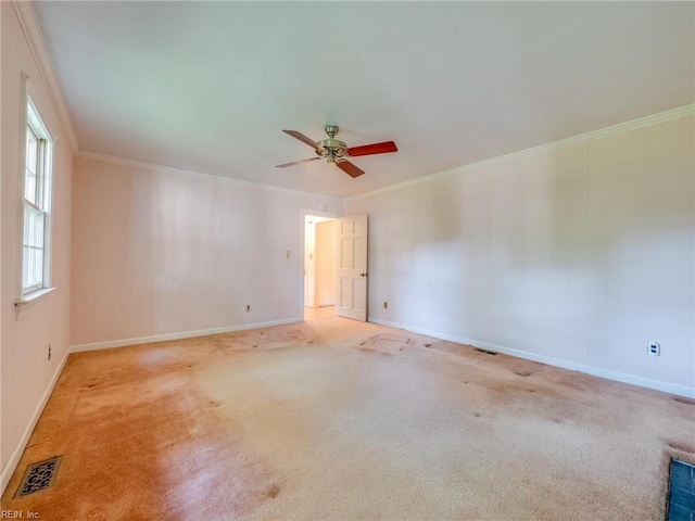 carpeted empty room featuring visible vents, ornamental molding, baseboards, and ceiling fan