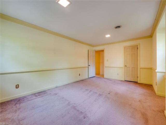 carpeted spare room with visible vents, crown molding, and baseboards