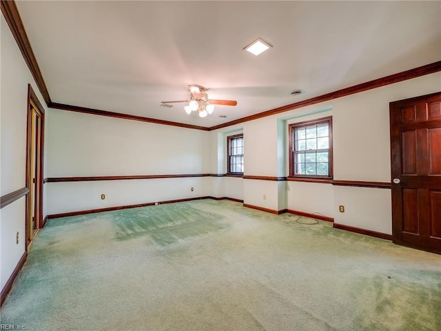 spare room featuring a ceiling fan, baseboards, ornamental molding, and carpet