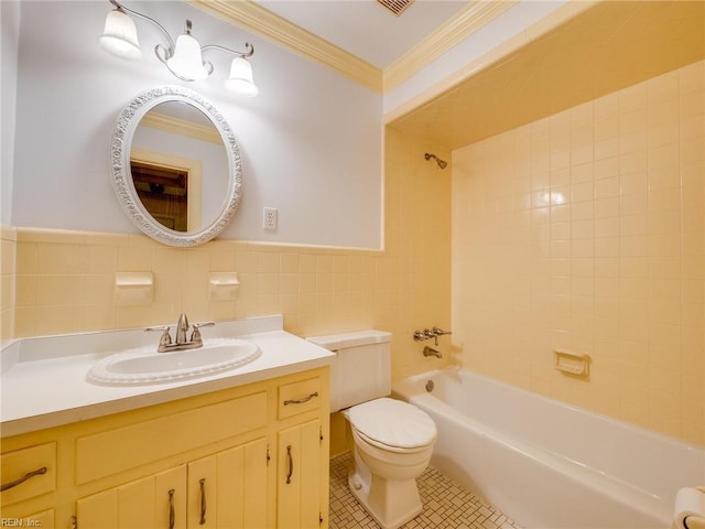 bathroom with shower / washtub combination, toilet, vanity, ornamental molding, and tile walls