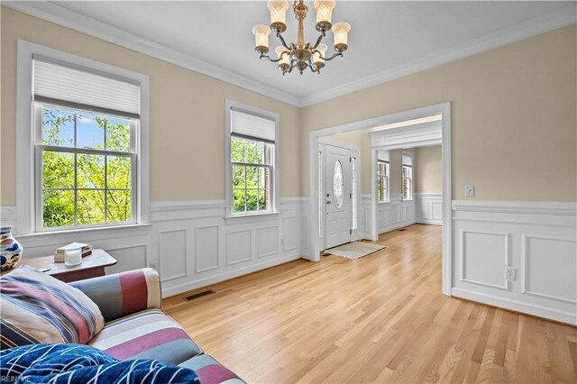 4011 E Providence Rd, Williamsburg, VA 23188 - living room featuring plenty of natural light, ornamental molding, a notable chandelier, and wainscoting