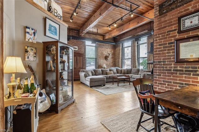 living room with wood-type flooring, rail lighting, wood ceiling, and brick wall