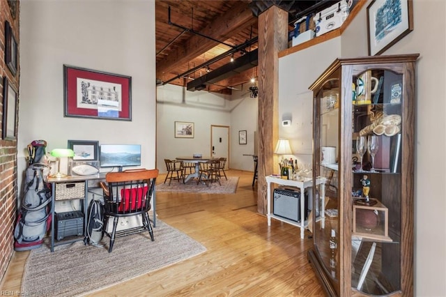 office space with wood finished floors, beam ceiling, wood ceiling, and a high ceiling