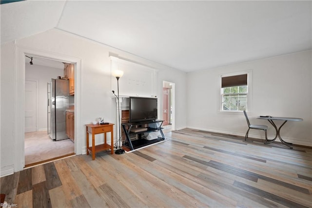 living area with baseboards and light wood finished floors