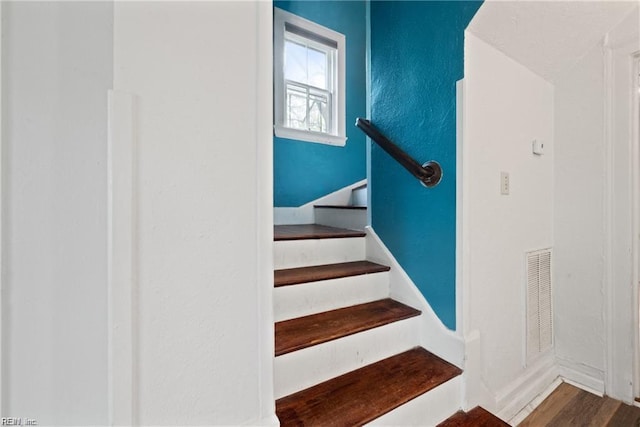 staircase with wood finished floors and visible vents