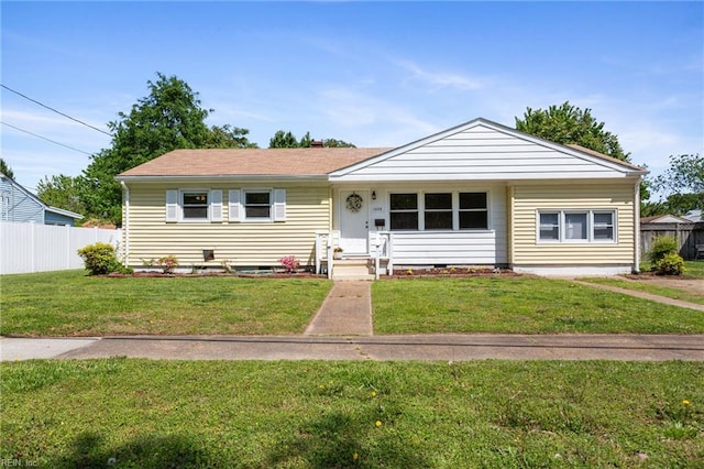 view of front of home with a front lawn and fence