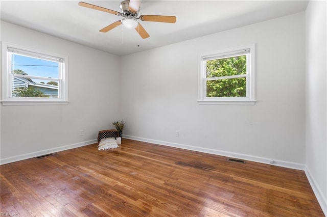unfurnished room with baseboards, visible vents, wood finished floors, and a ceiling fan