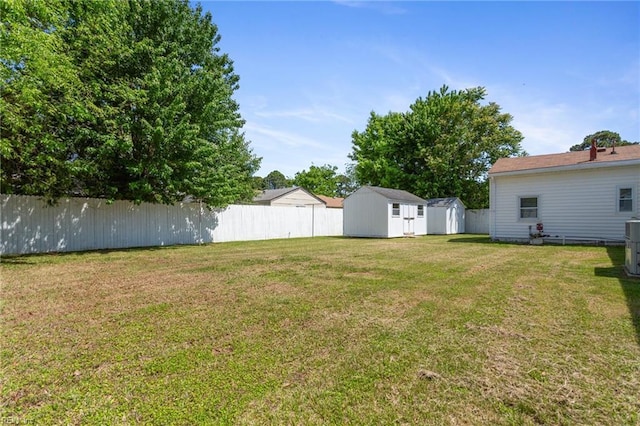 view of yard featuring an outdoor structure, a shed, and fence private yard