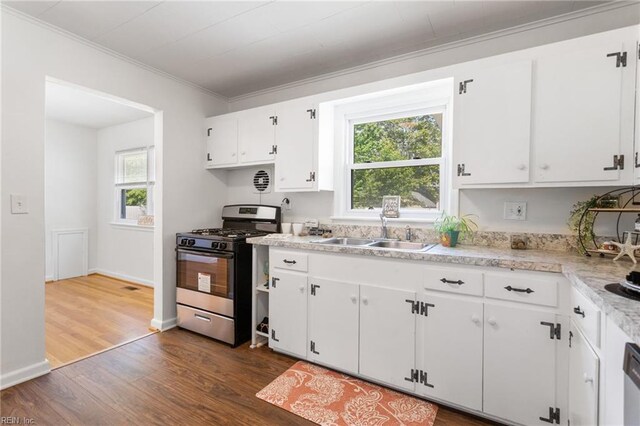 kitchen featuring light countertops, ornamental molding, a sink, dark wood-style floors, and stainless steel range with gas stovetop