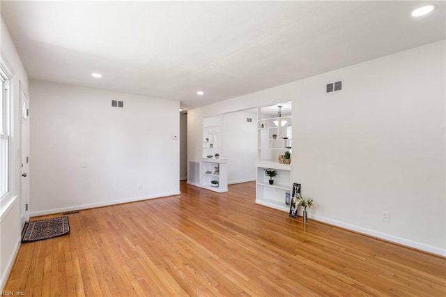 unfurnished living room with baseboards, recessed lighting, and light wood finished floors