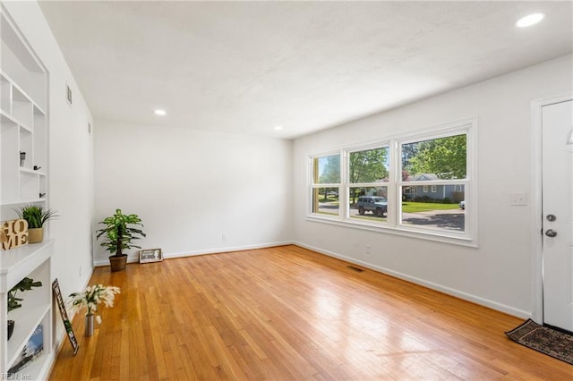 spare room featuring baseboards, visible vents, light wood-type flooring, and recessed lighting