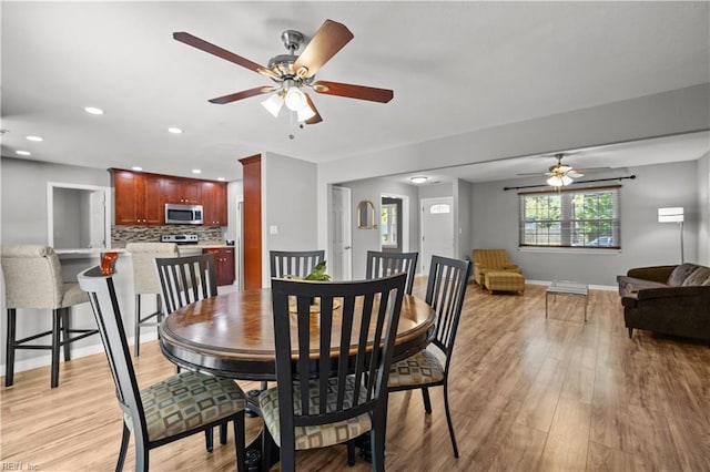 dining area with light wood-style floors, a ceiling fan, baseboards, and recessed lighting