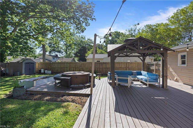 deck featuring a gazebo, a hot tub, an outdoor hangout area, a shed, and a fenced backyard