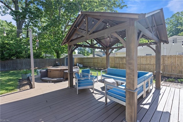 deck with a hot tub, a gazebo, a fenced backyard, and an outdoor hangout area