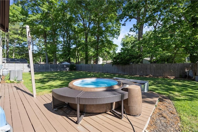 deck with a fenced backyard, cooling unit, a yard, and an outdoor hot tub