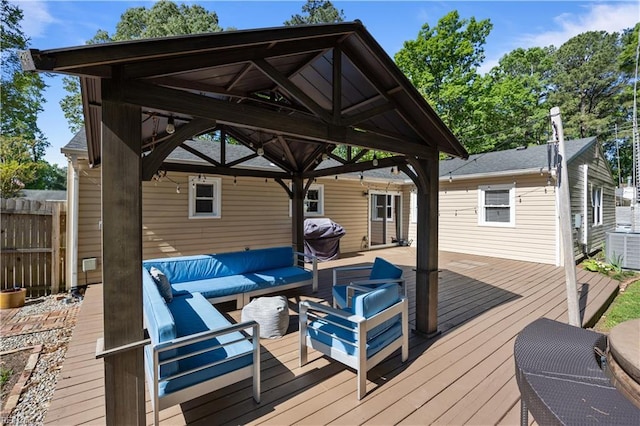 wooden deck featuring an outdoor living space, central air condition unit, a gazebo, fence, and a grill
