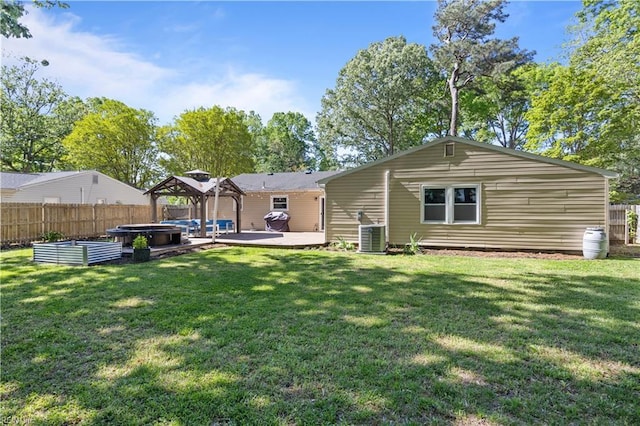 rear view of property with fence, a patio, a gazebo, a hot tub, and a yard