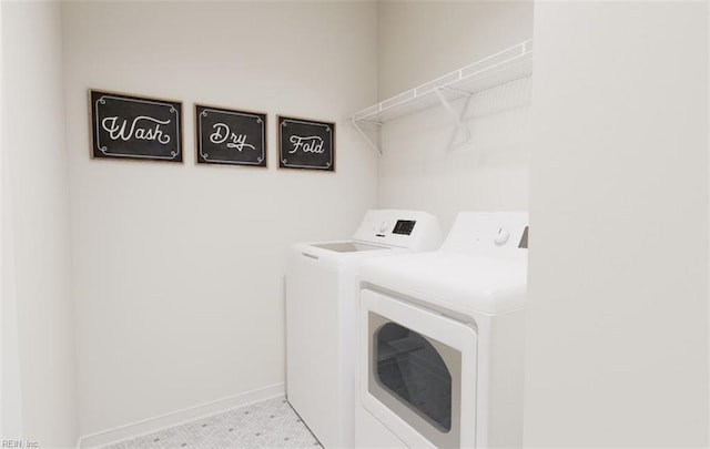 washroom with baseboards, laundry area, and washing machine and clothes dryer