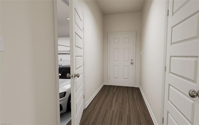 doorway to outside featuring dark wood-style flooring and baseboards