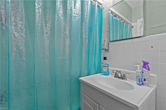 full bath with tile walls, backsplash, and vanity
